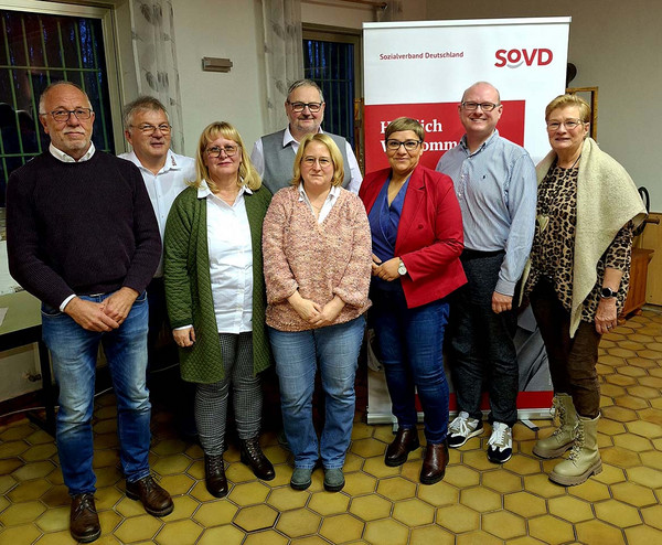 Gruppenbild mit acht Personen vor einem SoVD-Aufsteller. 