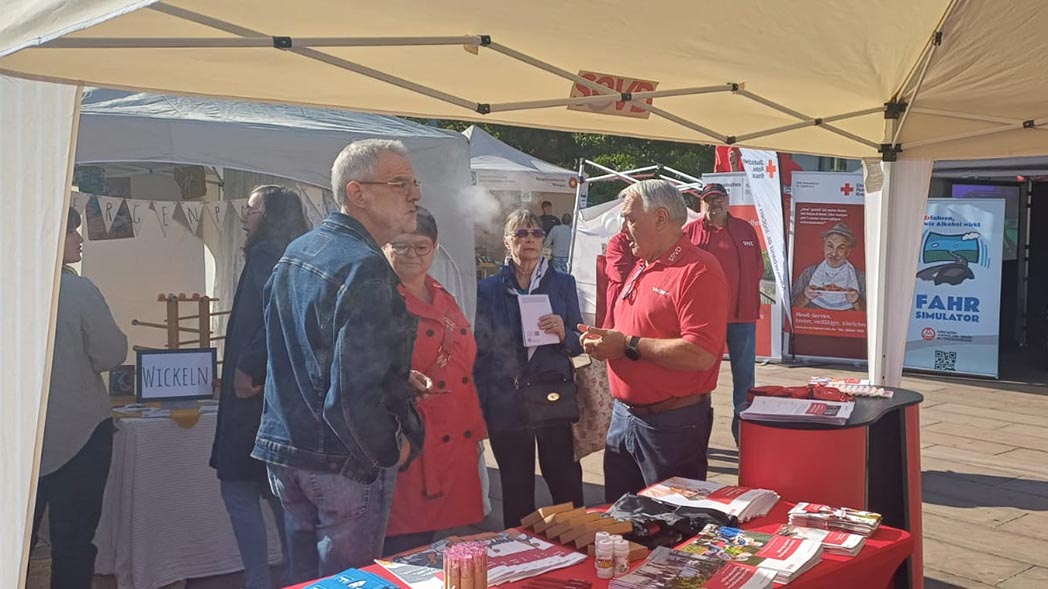 Infostand mit Menschen im Gespräch