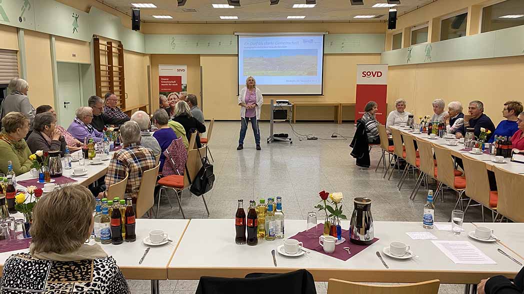Großer Saal mit vielen Menschen am Tisch